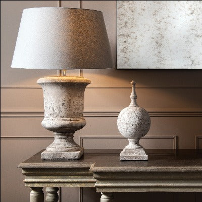 Birkdale stone finial displayed next to a lamp on a console table.