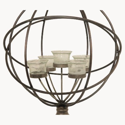 Close up of metal globe sphere candle holder with 5 glass tea light holders on the inside