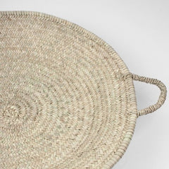 Moroccan oversized woven palm leaf basket close up image with side handle