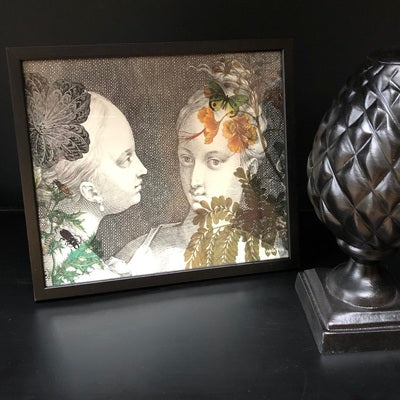 Femmes (two vintage women in black and white facing each other, with small accents of green and orange, Poster & Black Frame, 20 x 25 cm