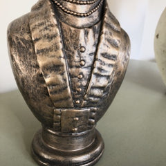 Close up of dog bust upper body in mans suit with beaded necklace.
