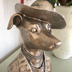 Head view of dog bust in bronze with top hat and a  3 string of beaded necklace